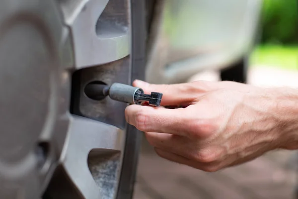 Fechar a mão do homem a descolar a válvula. Controlo da pressão dos pneus . — Fotografia de Stock