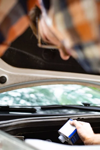 Hombre revisando y llenando niveles de fluido en el auto. Control del vehículo . —  Fotos de Stock