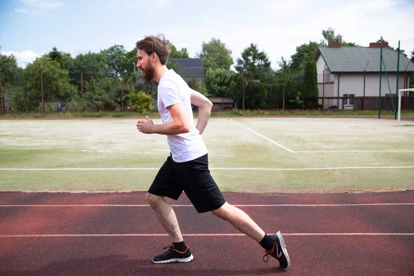 경기장의 달리기 트랙에서 달리기 훈련을 선수의 모습이 수평으로 보인다 운동복을 — 스톡 사진