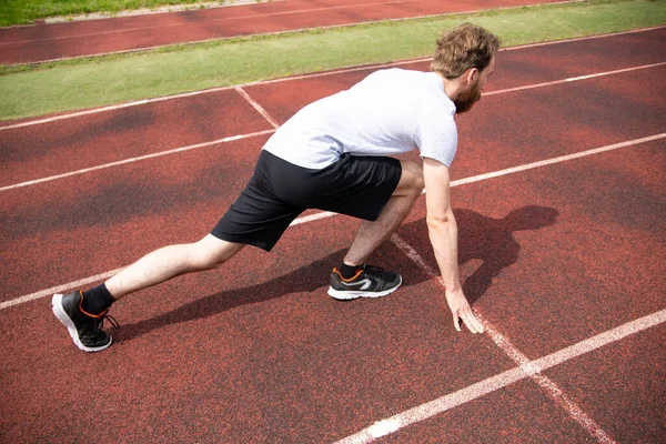 Sprinter Einer Startposition Auf Einer Roten Stadionlaufbahn Ein Männlicher Sportler — Stockfoto