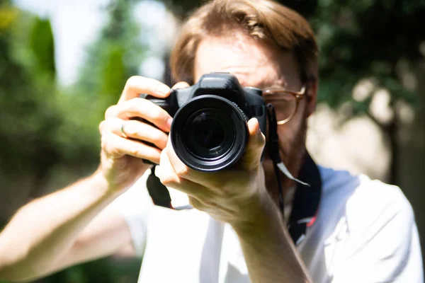 一个留着胡子的年轻人 戴着眼镜 带着专业数码相机在户外拍照 前视镜 风景摄影 户外摄影会 — 图库照片