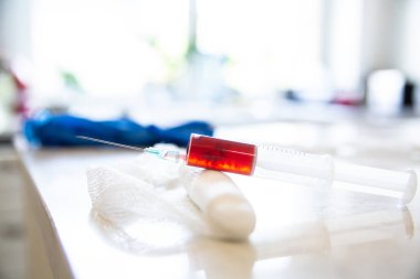 Üzerinde analiz için kan örneği olan bir şırınga. Tıbbi bir kompozisyon, konsept.