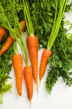 Beyaz arkaplanda yaprakları olan altı havuç ve kopyalama alanı