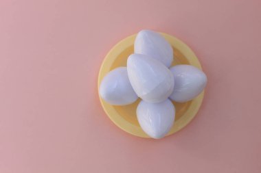 Plastik oyuncaklar yumurta pembe bir arka plan üzerinde kapat