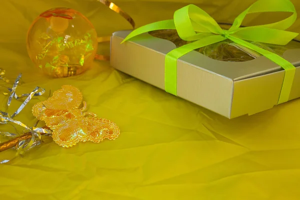 Caixa de presente de prata amarrado laço fita amarela no fundo amarelo — Fotografia de Stock