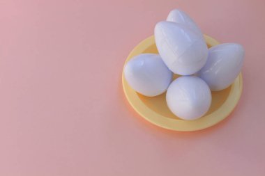 Plastik oyuncaklar yumurta pembe bir arka plan üzerinde kapat