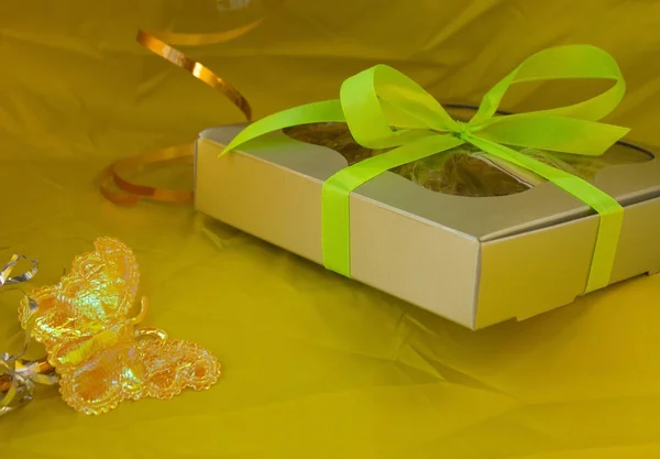 Caja de regalo de plata atada lazo de cinta amarilla sobre fondo amarillo — Foto de Stock