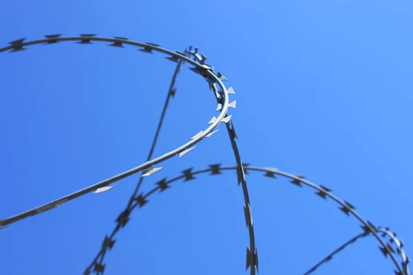 Barbed wire on fence with blue sky, the concept of prison, salvation, copy space. — Stock Photo, Image