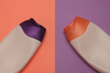 Güzellik, dekoratif kozmetik şişeleri. Şeftali ve mor renkler arka plan, düz yatıyordu, üst görünüm, minimalist pop-art tarzı