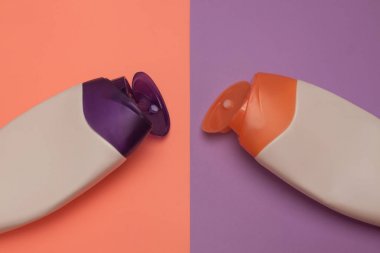 Güzellik, dekoratif kozmetik şişeleri. Şeftali ve mor renkler arka plan, düz yatıyordu, üst görünüm, minimalist pop-art tarzı