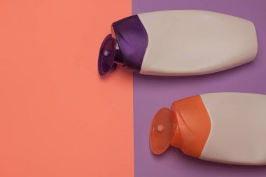 Güzellik, dekoratif kozmetik şişeleri. Şeftali ve mor renkler arka plan, düz yatıyordu, üst görünüm, minimalist pop-art tarzı