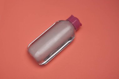 Cilt bakımı kozmetik şişe, temizlik ve makyaj kaldırmak için ürün, üst görünüm, pastel renk arka plan, minimalist.