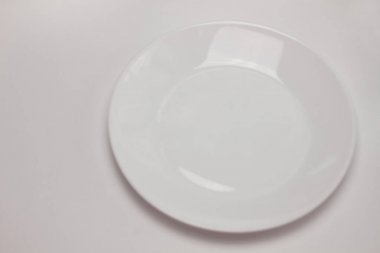 Boş yuvarlak beyaz plaka beyaz arka plan üzerinde izole. Üst görünüm, düz döşeme, kopyalama alanı, mock up.