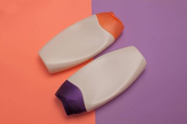 Güzellik, dekoratif kozmetik şişeleri. Şeftali ve mor renkler arka plan, düz yatıyordu, üst görünüm, minimalist pop-art tarzı