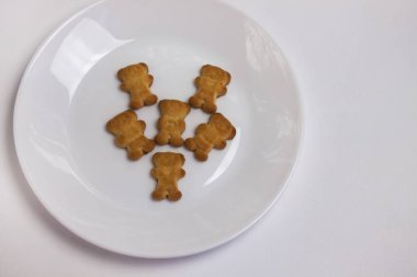 Beyaz arka plan üzerinde izole seramik yuvarlak plaka üzerinde Sevimli ayılar çerezleri. Yukarıdan görünüm, düz yatıyordu.