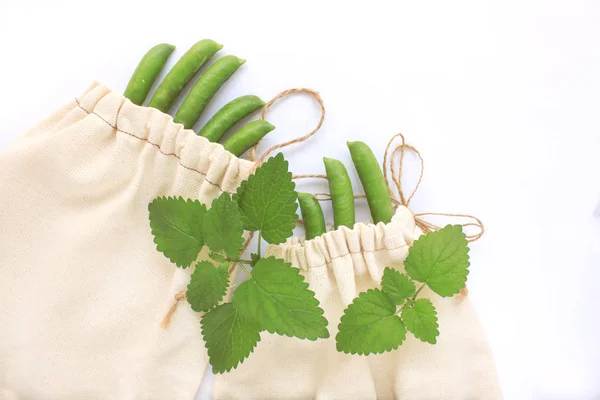 Concepto de cero residuos, bolsas de algodón reutilizables para compras de plástico gratis, guisantes, salvar el planeta, vida de estilo ecológico, espacio de copia — Foto de Stock