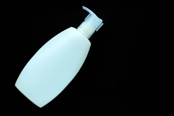 White cosmetic bottle for liquid soap on black background isolated. Container for a cream, shampoo, oil, gel,body balsam