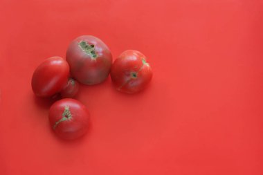 Çirkin gıda konsepti, kırmızı arka planda deforme domates, kopya alanı.