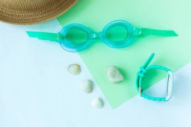 Watersport gözlük, şapka, nane ve açık mavi arka plan, minimalist tarzı, kopya alanı izlemek ile yaz flatlay.