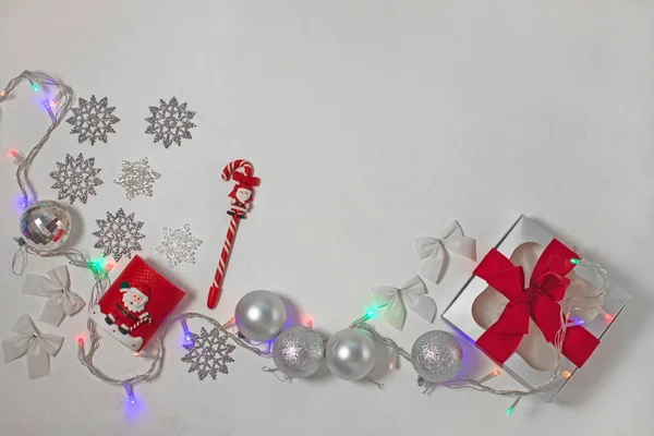 Composition de Noël de décorations rouges et argentées, boîte cadeau avec ruban papillon, flatlay . — Photo