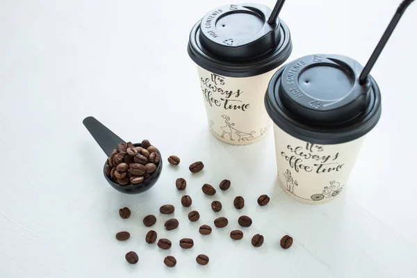 Tazza di caffè di carta da caffetteria con chicchi di caffè vicino alla finestra. Stile di vita concetto . — Foto Stock