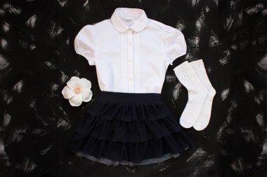Beyaz gömlek, çorap ve siyah arka planda koyu denim etek ile okul üniforması. Flatlay, üst görünüm, kopya alanı.