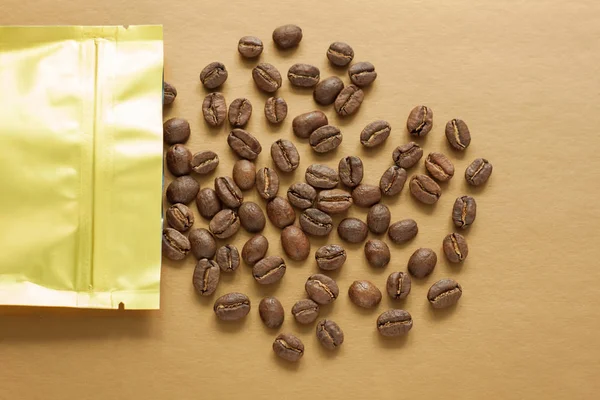 Золотая фольга мешок с кофейными зёрнами на золотом фоне. Упаковка шаблона макета. Алюминиевый пакет для чая, плоский . — стоковое фото