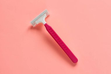 Pembe pastel arka plan, flatley, kopyalama alanı üzerinde kadınlar için tek kullanımlık tıraş makinesi.