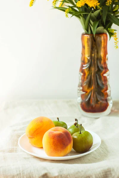 Still life with fresh peaches and plums on linen cloth background on wooden table. Bright juicy summer fruits. — Stock Photo, Image