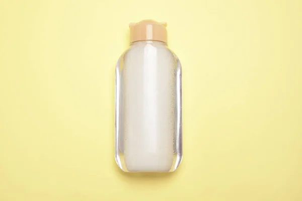 Контейнер для бутылок на светло-желтом фоне. Продукт для очистки, удаления макияжа . — стоковое фото