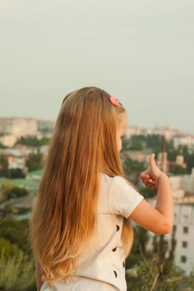 Bir doğa üzerinde beyaz bir t-shirt uzun sarı saçlı küçük kız — Stok fotoğraf