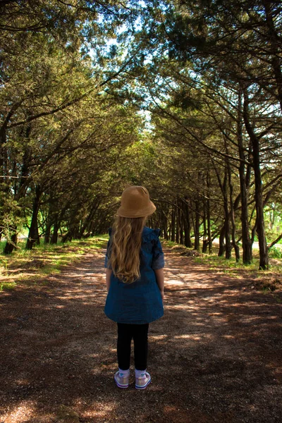 Una niña en el fondo del paisaje de belleza. Un niño con una camisa de mezclilla y un sombrero de paja . —  Fotos de Stock