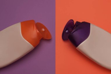 Güzellik, dekoratif kozmetik şişeleri. Şeftali ve mor renkler arka plan, düz yatıyordu, üst görünüm, minimalist pop-art tarzı