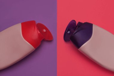 Güzellik, dekoratif kozmetik şişeleri. Pembe ve mor renkler arka plan, düz yatıyordu, üst görünüm, minimalist pop-art tarzı