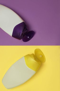 Güzellik, dekoratif kozmetik şişeleri. Şeftali ve mor renkler arka plan, düz yatıyordu, üst görünüm, minimalist pop-art tarzı
