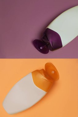 Güzellik, dekoratif kozmetik şişeleri. Şeftali ve mor renkler arka plan, düz yatıyordu, üst görünüm, minimalist pop-art tarzı