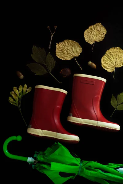 Botas de goma rojas sobre fondo negro. Concepto de otoño —  Fotos de Stock
