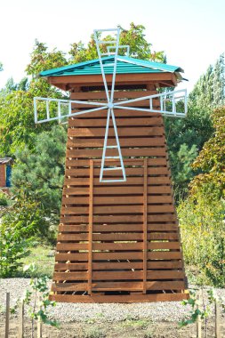 Bir ahşap doğal vintage yel değirmeni. Arka planda mavi gökyüzü.