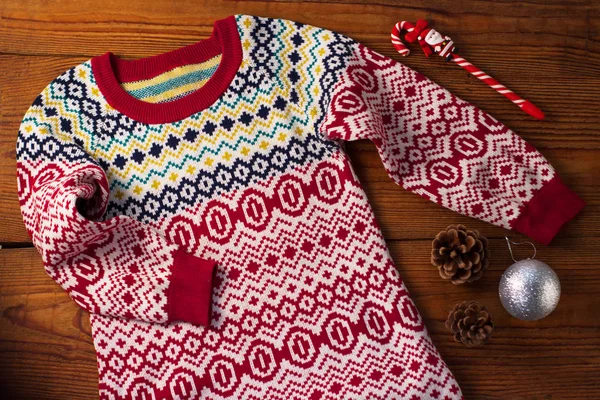Jersey de invierno de punto lindo con adornos coloridos, decoraciones de Navidad, conos de pino y piruleta de Santa. . — Foto de Stock