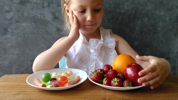 Menina Com Frutas Frescas Doces Mesa Casa Criança Pensa Que — Vídeo de Stock