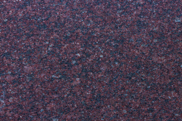 Dark purple granite background used for kitchen worktop, table, window sill, fence. Red violet igneous rock stones texture. Text sign advertising design mockup. Architecture detail natural backdrop.