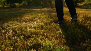 Ayaklar renkli kırmızı yeşil sonbahar çimen sporlarında ısınıyor. Kotlu buzağılar ve spor ayakkabılar ormanda yürüyor. Temiz hava akımı. Aktif yaşam tarzı zayıflaması basit eğitim