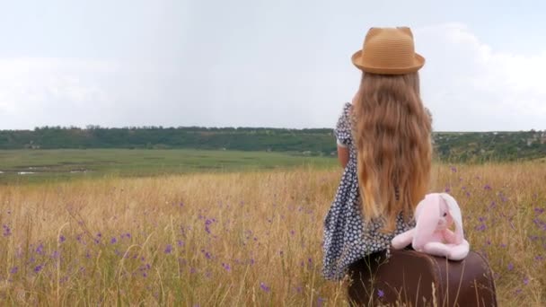 Barnflicka Med Långt Hår Halmhatt Och Klänning Sitter Vintage Resväska — Stockvideo