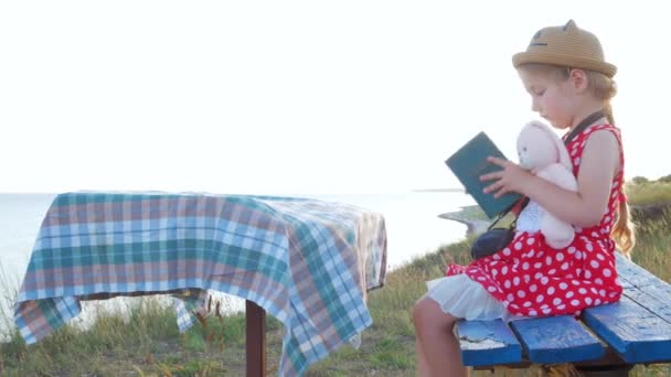 Hasır Şapkalı Elbiseli Çocuk Klasik Bankta Oturup Kitap Okuyor Yumuşak — Stok video