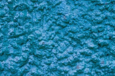 Eski turkuaz alçı duvar dokusu. Retro boyalı macun bina arka planında kopyalama alanı var. Şık mavi yüzey, ayrıntılı taşlar arka plan. Metin tasarımı için duvar kağıdı desenli ekran koruyucu öngörünümü.