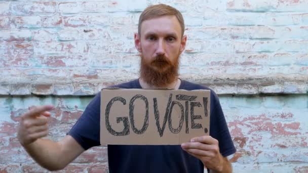 Mann Zeigt Pappe Mit Vote Zeichen Auf Backsteinmauer Städtischen Hintergrund — Stockvideo