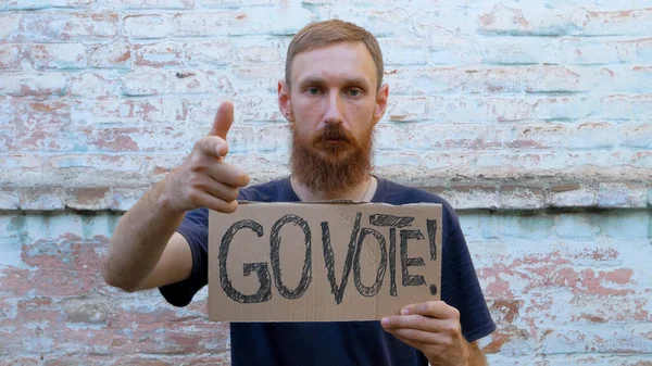 Hombre Muestra Cartulina Con Vote Signo Pared Ladrillo Fondo Urbano —  Fotos de Stock