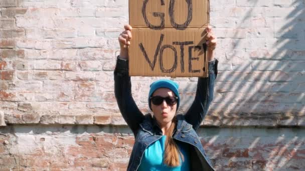 Mujer Muestra Cartulina Con Vote Signo Pared Ladrillo Fondo Urbano — Vídeos de Stock
