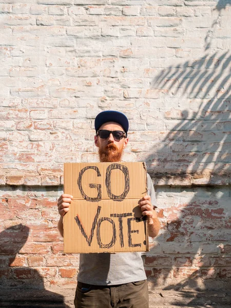 Hombre Muestra Cartulina Con Vote Signo Pared Ladrillo Fondo Urbano —  Fotos de Stock