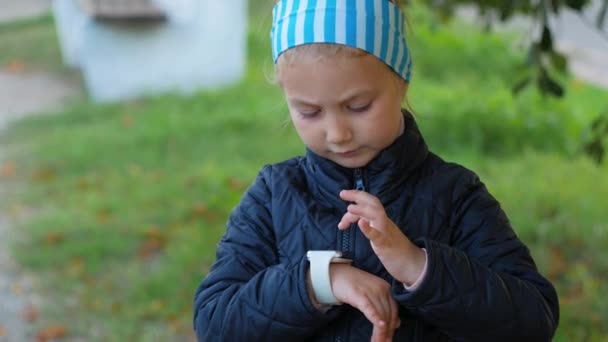 Barn Använder Smartwatch Utomhus Höstparken Grabben Pratar Vdeo Samtal Smartphone — Stockvideo